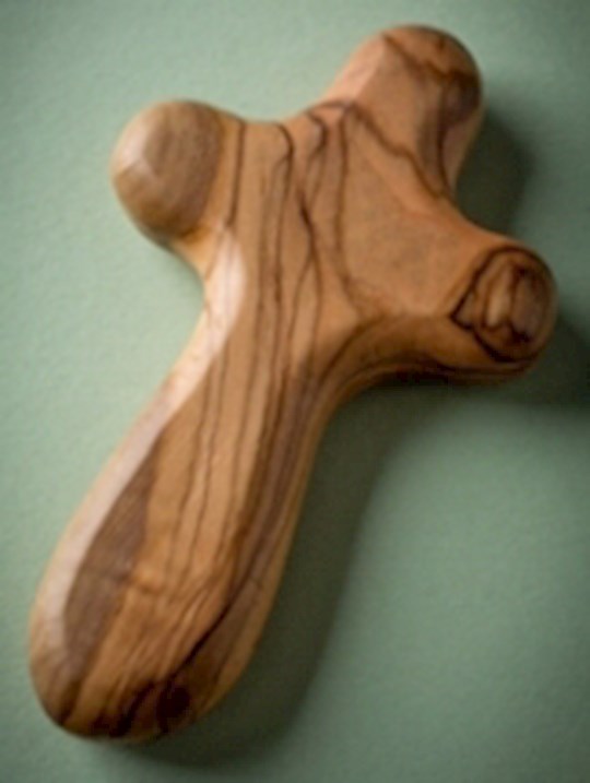 A small olive wood cross with visible wood grain, placed against a green background.