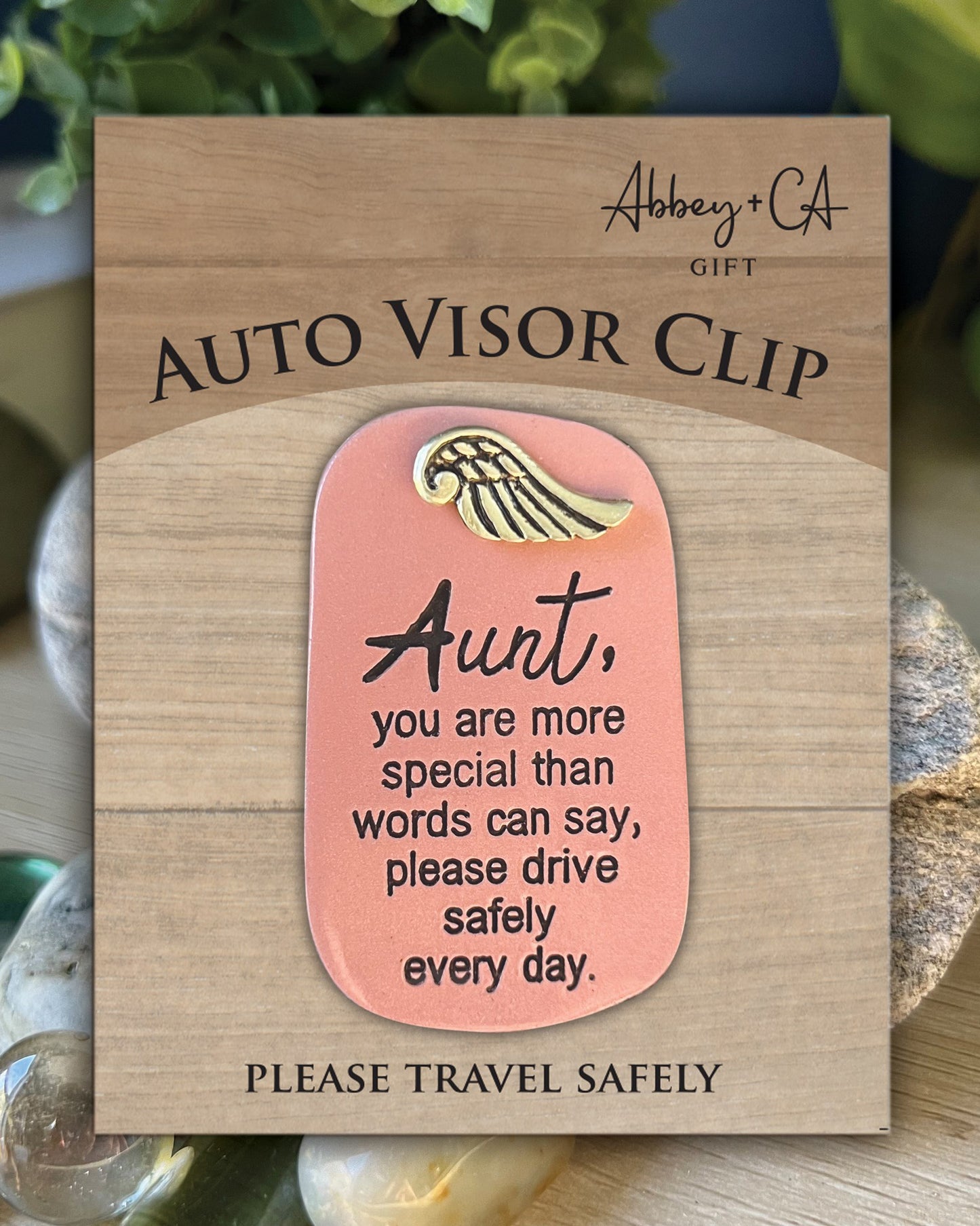 Auto visor clip with a message on a wooden card, featuring the brand 'Abbey & Co'.