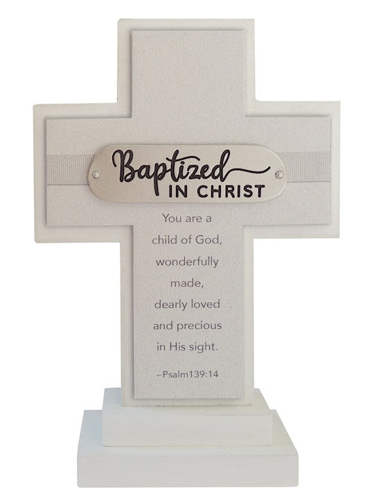 A white standing cross with a plaque that reads 'Baptized in Christ' and a verse from Psalm 139:14, placed on a stable base.