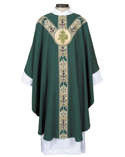 A person wearing a white and gold semi-gothic chasuble with embroidery and a round neck, standing in a church with a stained glass window in the background.