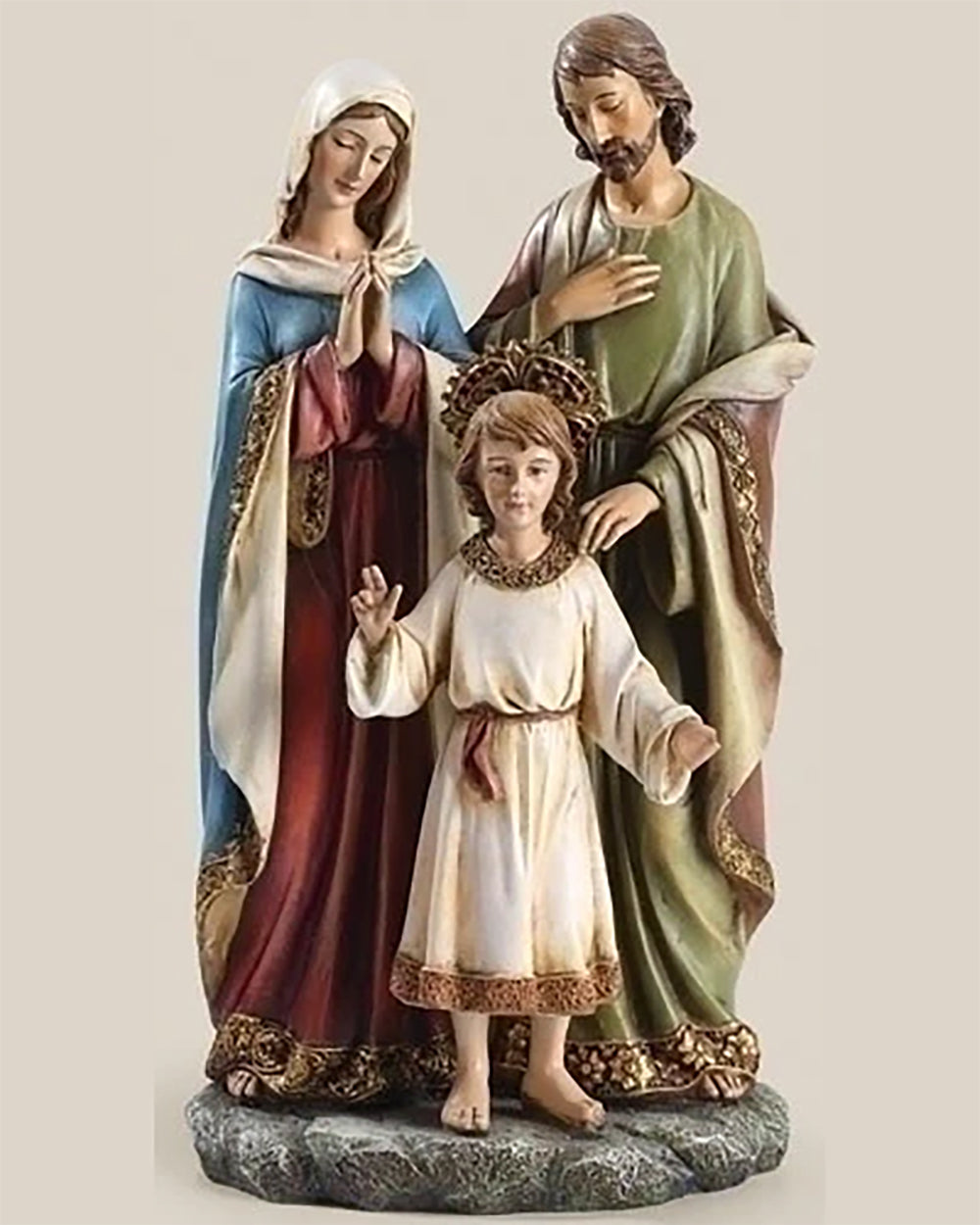 A statue of the Holy Family consisting of three figures: Mary in a blue dress, Joseph in a green robe, and Jesus in a white robe, standing close together.