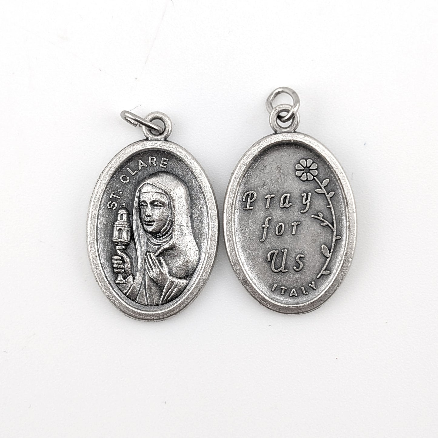 Silver religious pendant with a portrait and text on a white background