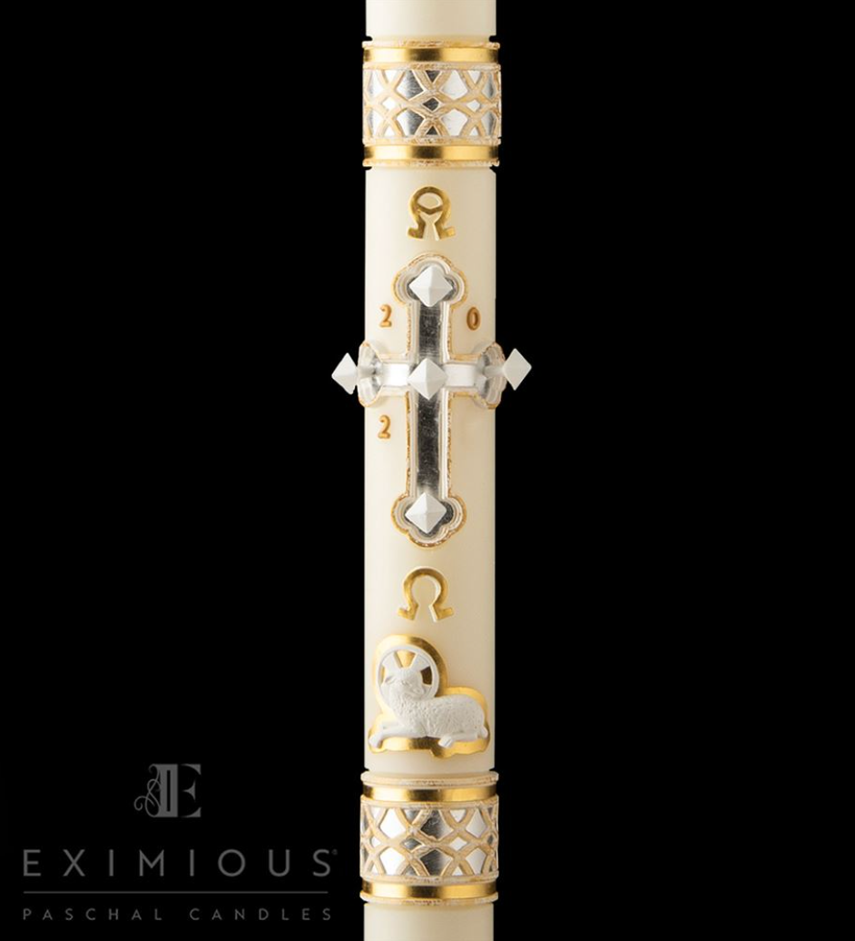 Decorative candle with gold and silver designs on a black background, featuring the brand 'Eximious'.