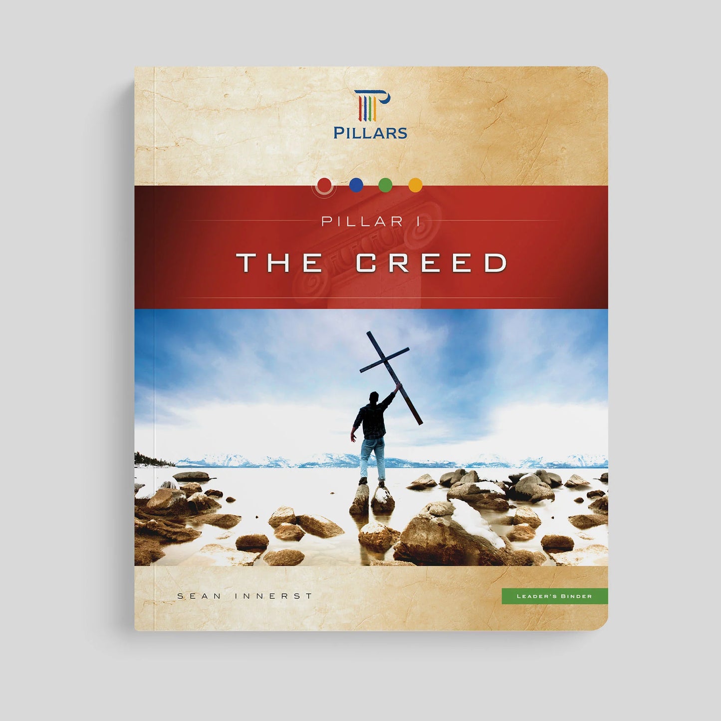 Book cover titled 'The Creed' by Pillars with a person holding a cross on a beach.
