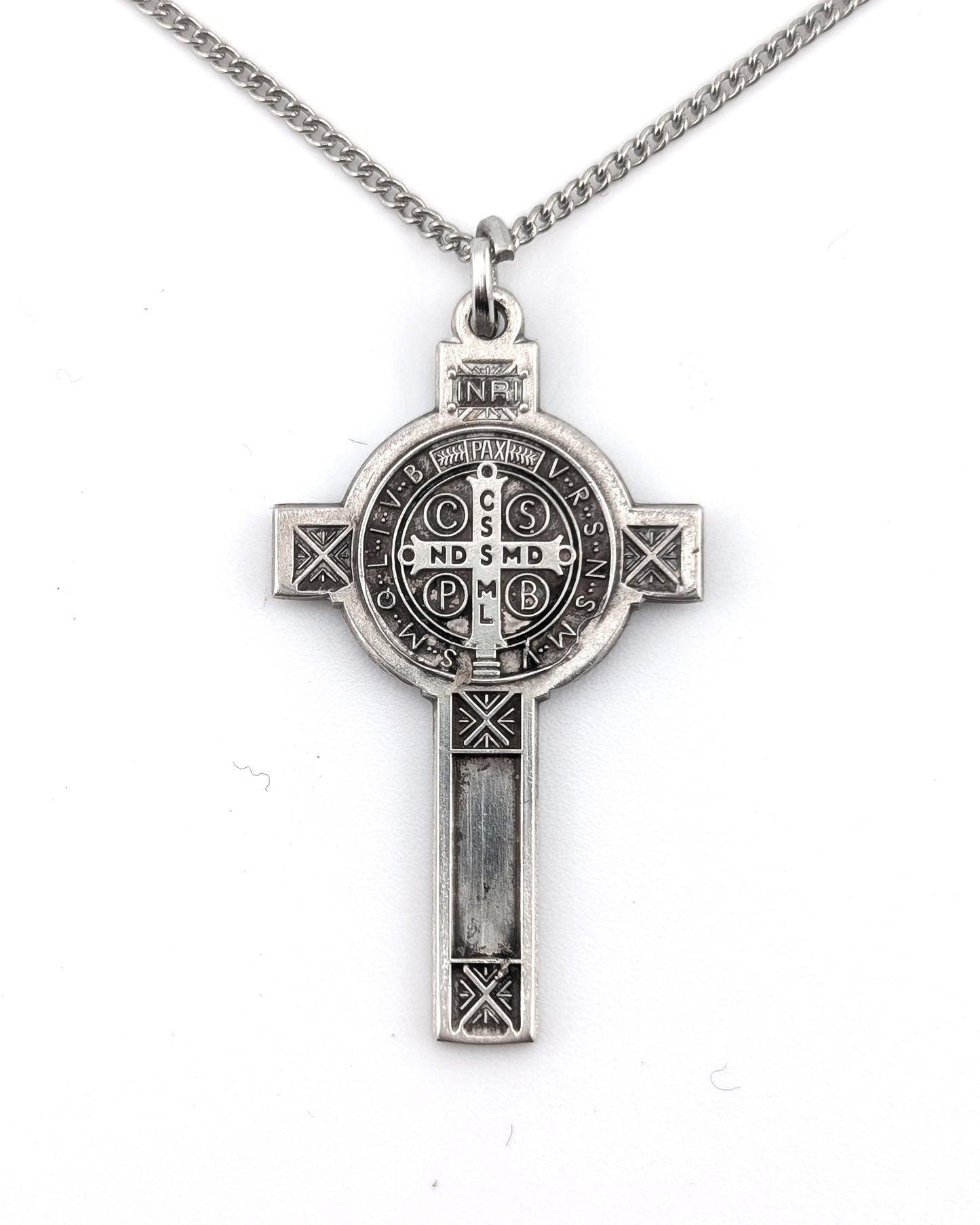 Silver cross pendant necklace on a white background