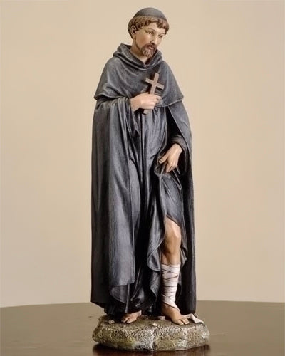 Statue of a monk holding a cross on a beige background