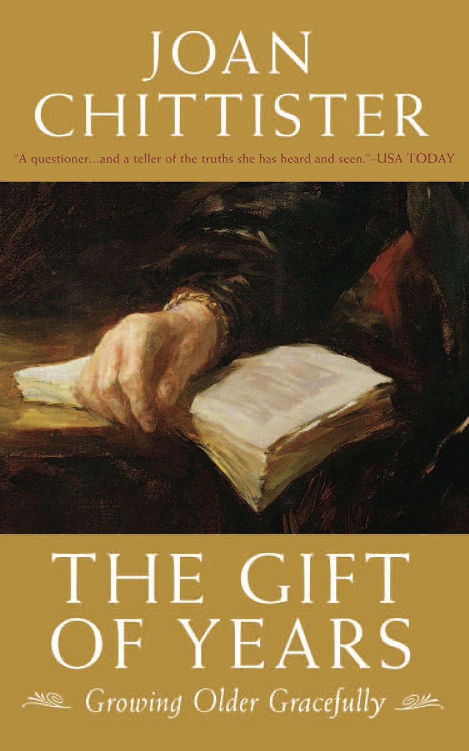 Book cover of 'The Gift of Years' by Joan Chittister with a hand holding an open book.