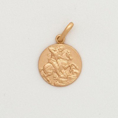 A gold round medal featuring an embossed image of a saint, attached to a gold loop for a chain.