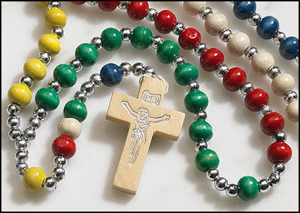 A colorful mission rosary with a wooden cross and beads in various colors including yellow, green, blue, white, and red, attached with metal rings.