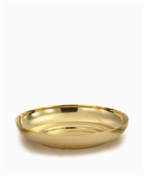 A gold-colored, round metal paten with a polished finish.