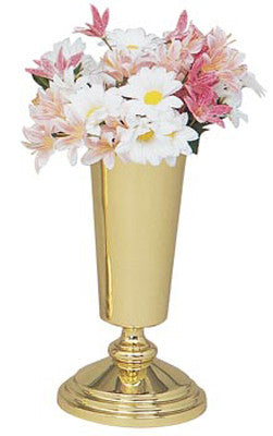 A gold-colored brass vase with a floral design, filled with artificial flowers, on a plain background.