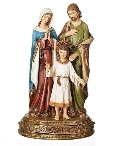 A statue of the Holy Family, featuring three figures, with a drawer on the base. The figures are dressed in colorful, traditional clothing and are depicted in a Devotional pose.