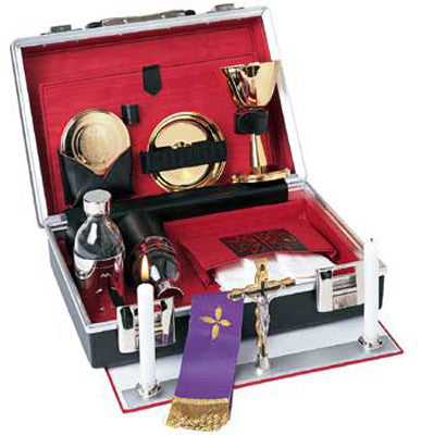 A complete mass kit containing a chalice, bowl, cruets, a cross, and candles, all displayed in an open red and silver case with a purple sash.