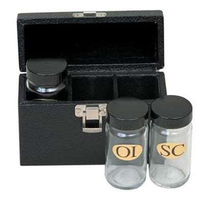 Three glass oil containers with black lids, placed in a black case with a metal clasp. The containers have labels OI, OS, SC respectively.