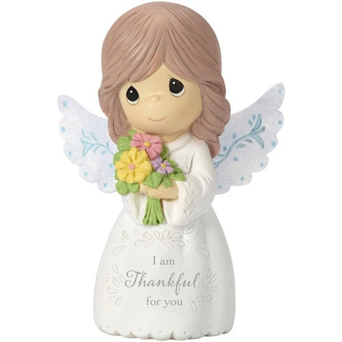 A resin statue of an angel holding a bouquet of flowers with the message 'I am Thankful for You' on its base.