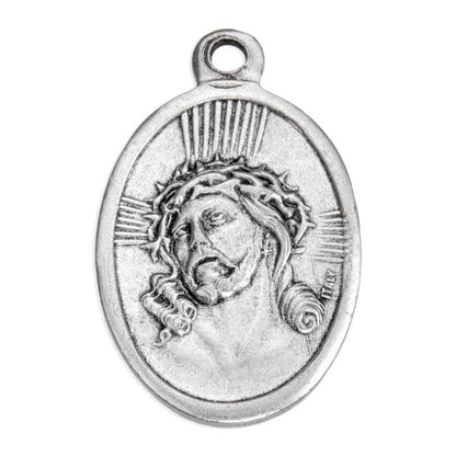 An oval silver-toned metal pendant featuring a relief carving of Jesus Christ's face wearing a crown of thorns, with radiating light lines and a hanging loop at the top, shown on a plain white background.