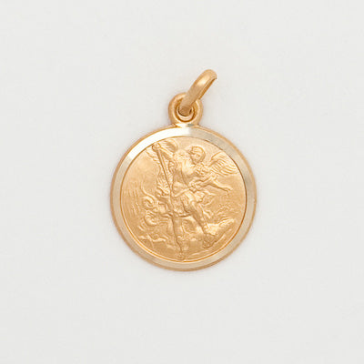 Gold pendant with an engraved design on a light gray background