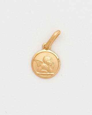 Gold pendant with a face design on a light gray background