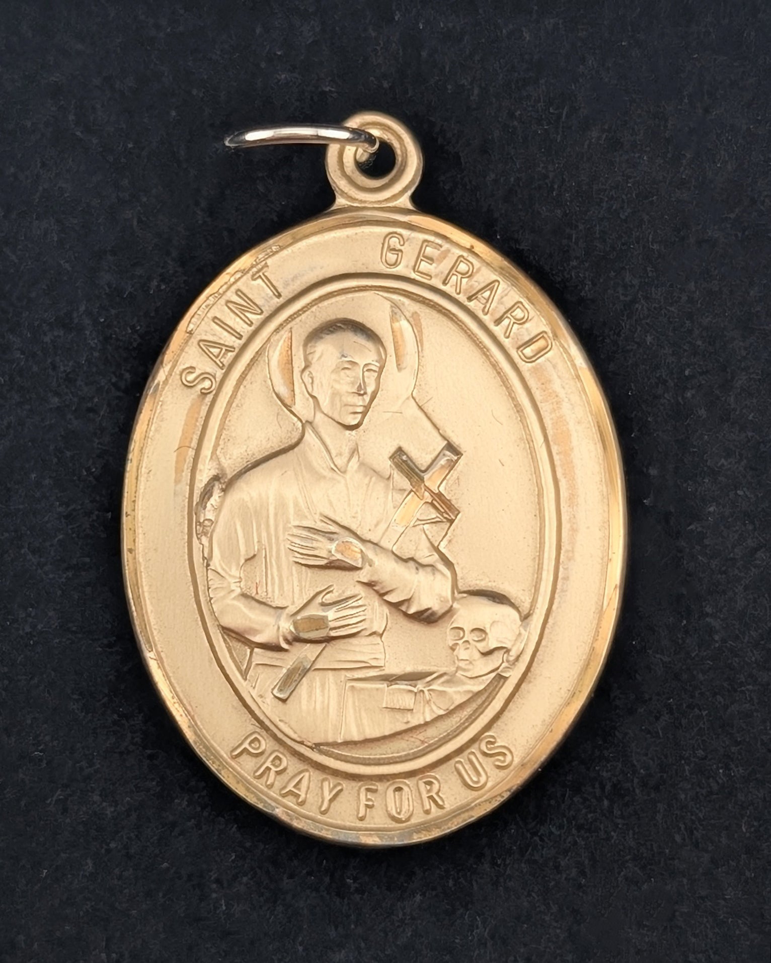 Gold Saint Gerard medal on a black background
