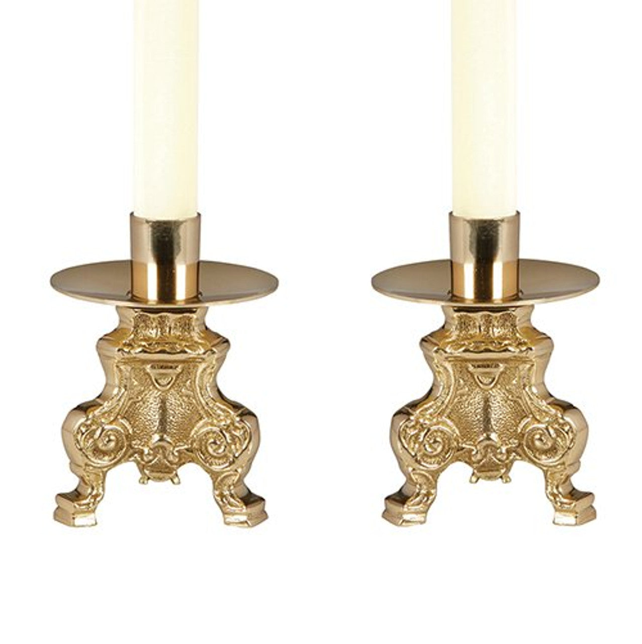 A pair of brass altar candlesticks with intricate designs, holding white candles.