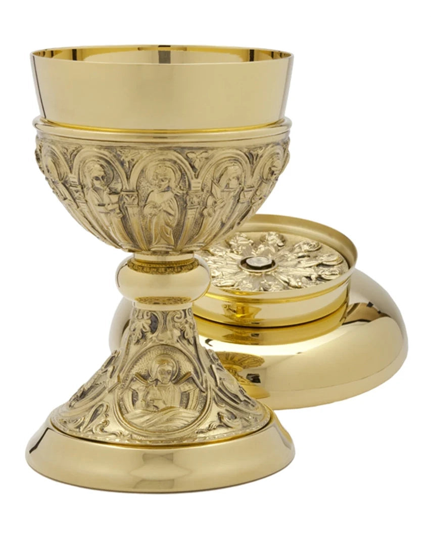 Gold chalice and paten set with intricate designs on a white background