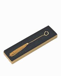 Gold tassel keychain on a black card with gold text on a white background