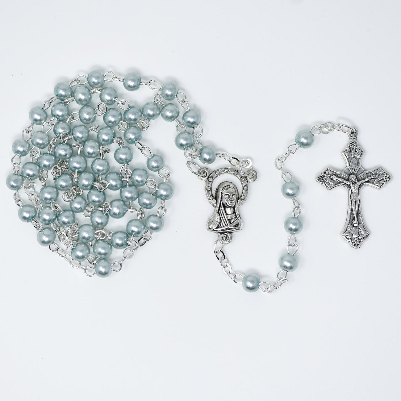 Silver rosary with beads and crucifix on a white background