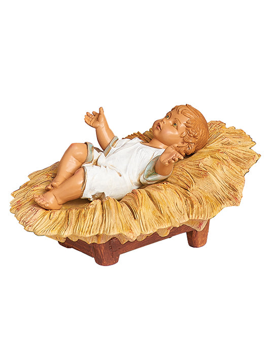 Baby Jesus figurine in a manger on a white background
