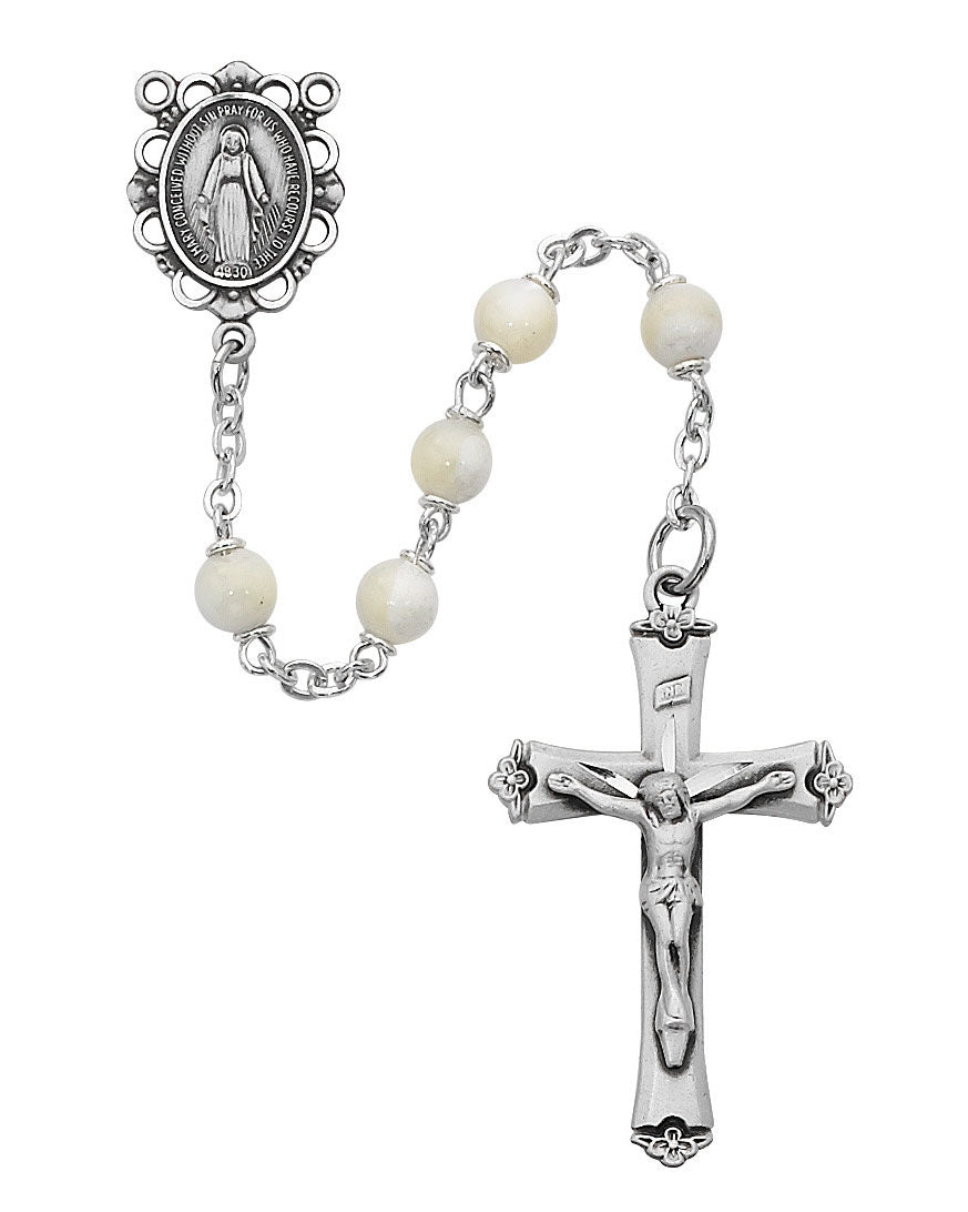 Silver rosary with white beads and crucifix on a white background
