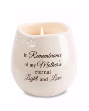 White candle in a textured holder with engraved text on a white background