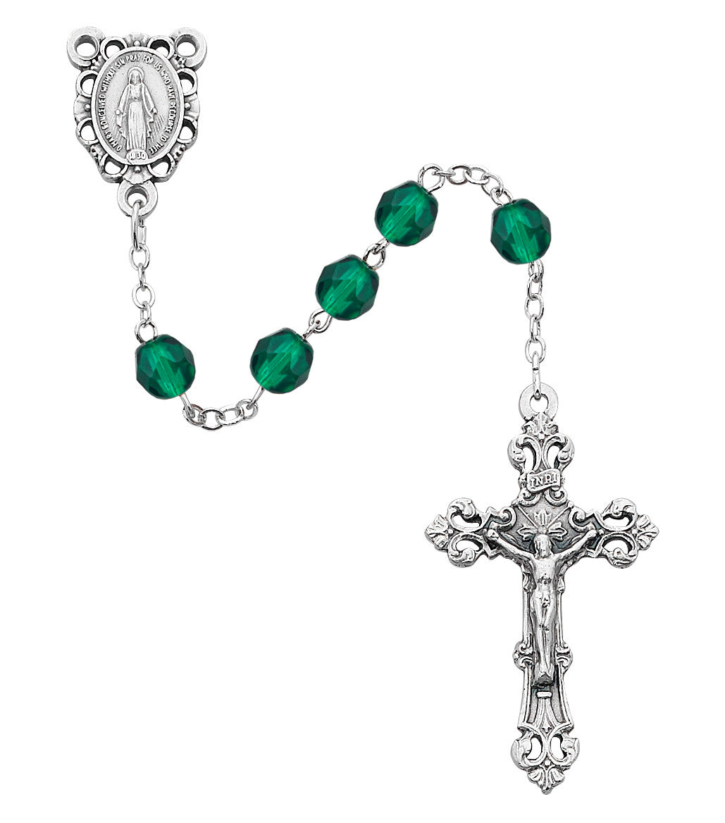 Silver rosary with green beads on a white background