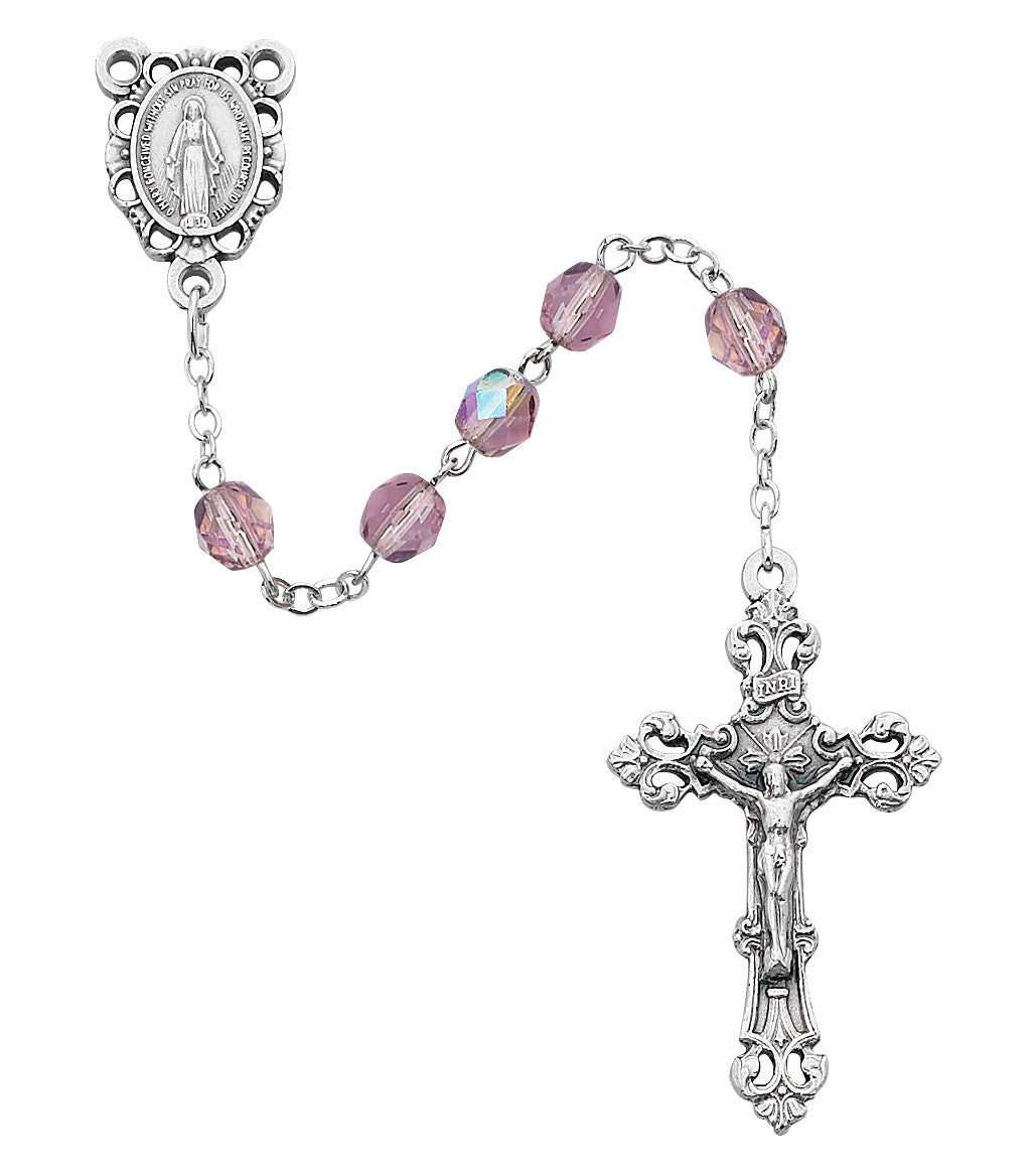 Silver rosary with pink beads on a white background