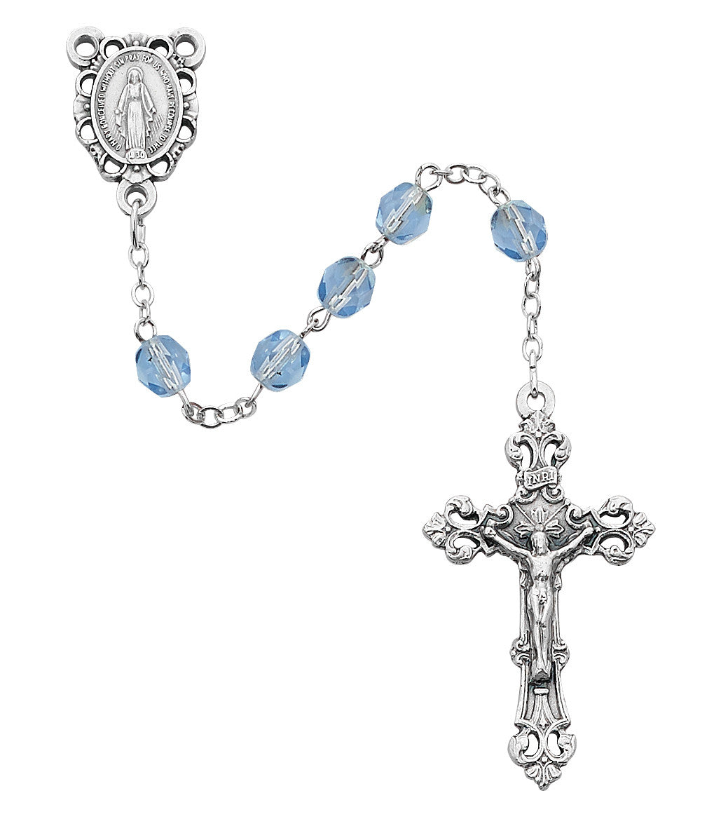 Silver rosary with blue beads on a white background