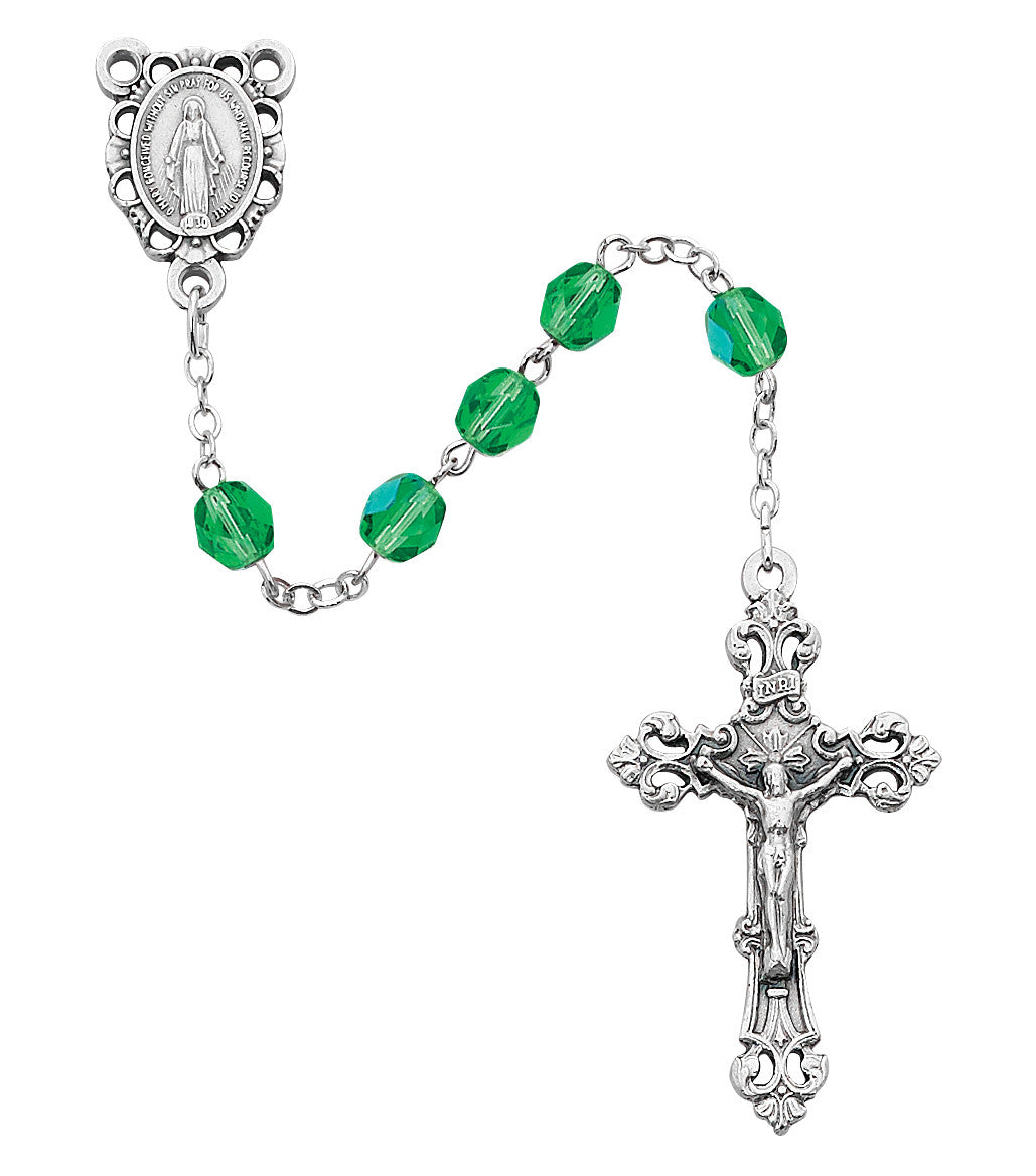 Silver rosary with green beads on a white background