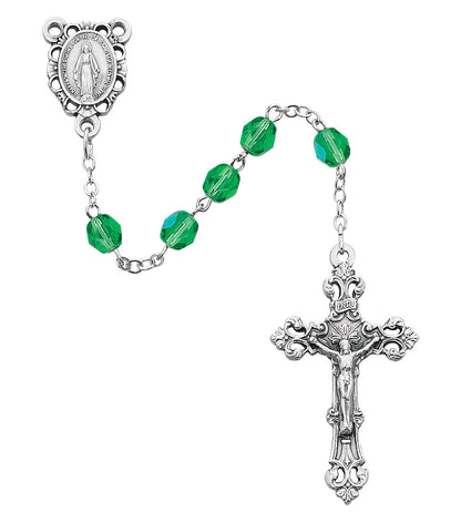 Silver rosary with green beads on a white background