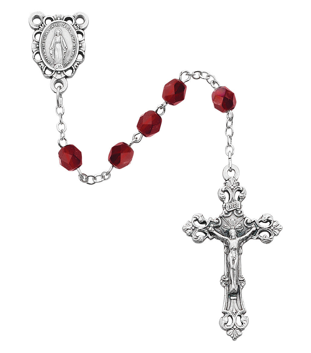 Silver rosary with red beads on a white background