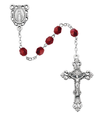 Silver rosary with red beads on a white background