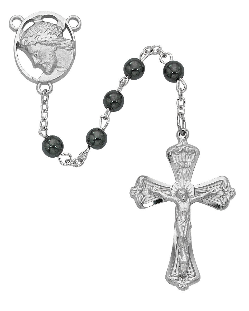 Silver rosary with black beads on a white background