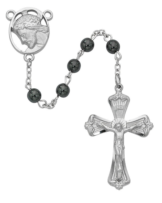 Silver rosary with black beads on a white background