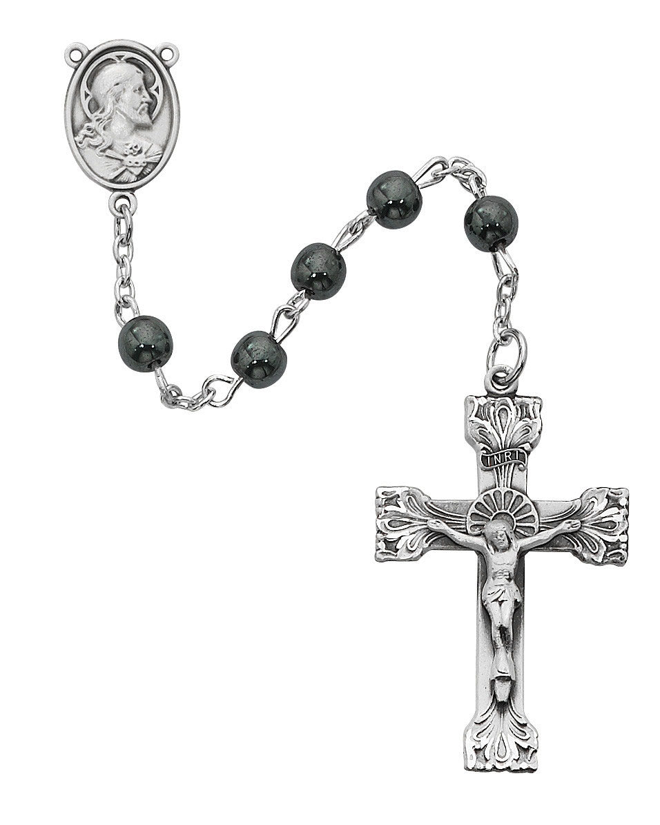 Silver rosary with black beads and crucifix on a white background