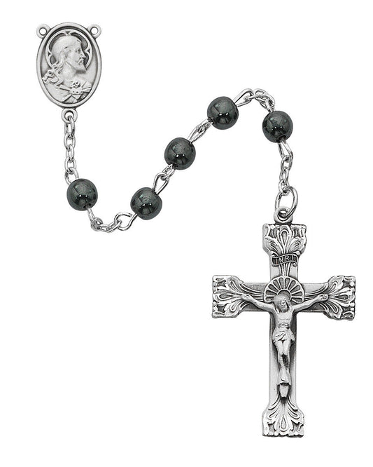 Silver rosary with black beads and crucifix on a white background