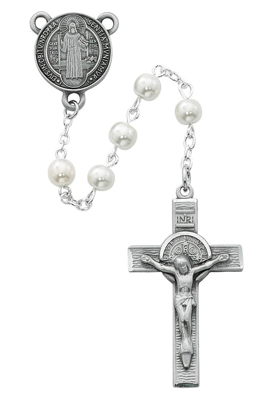 A rosary with white pearl beads and a St. Benedict centerpiece, including a cross.