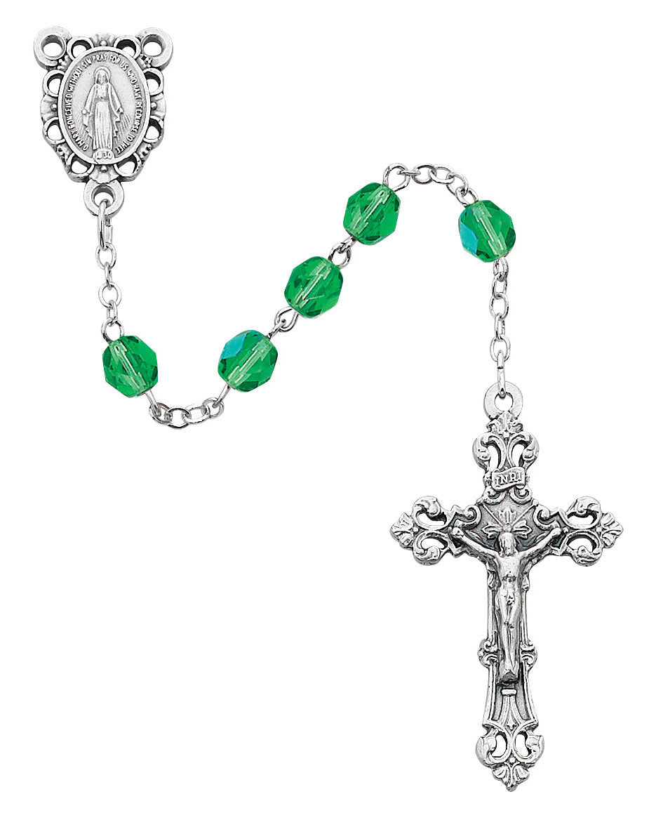 Rosary with green beads and silver crucifix on a white background