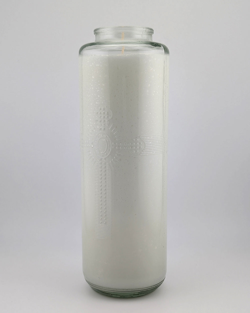 Tall glass candle with embossed design on a white background