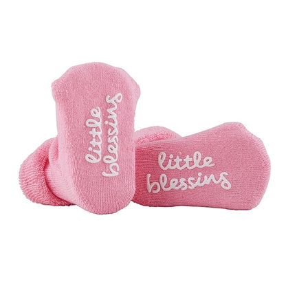 Pink socks with 'little blessing' text on a white background
