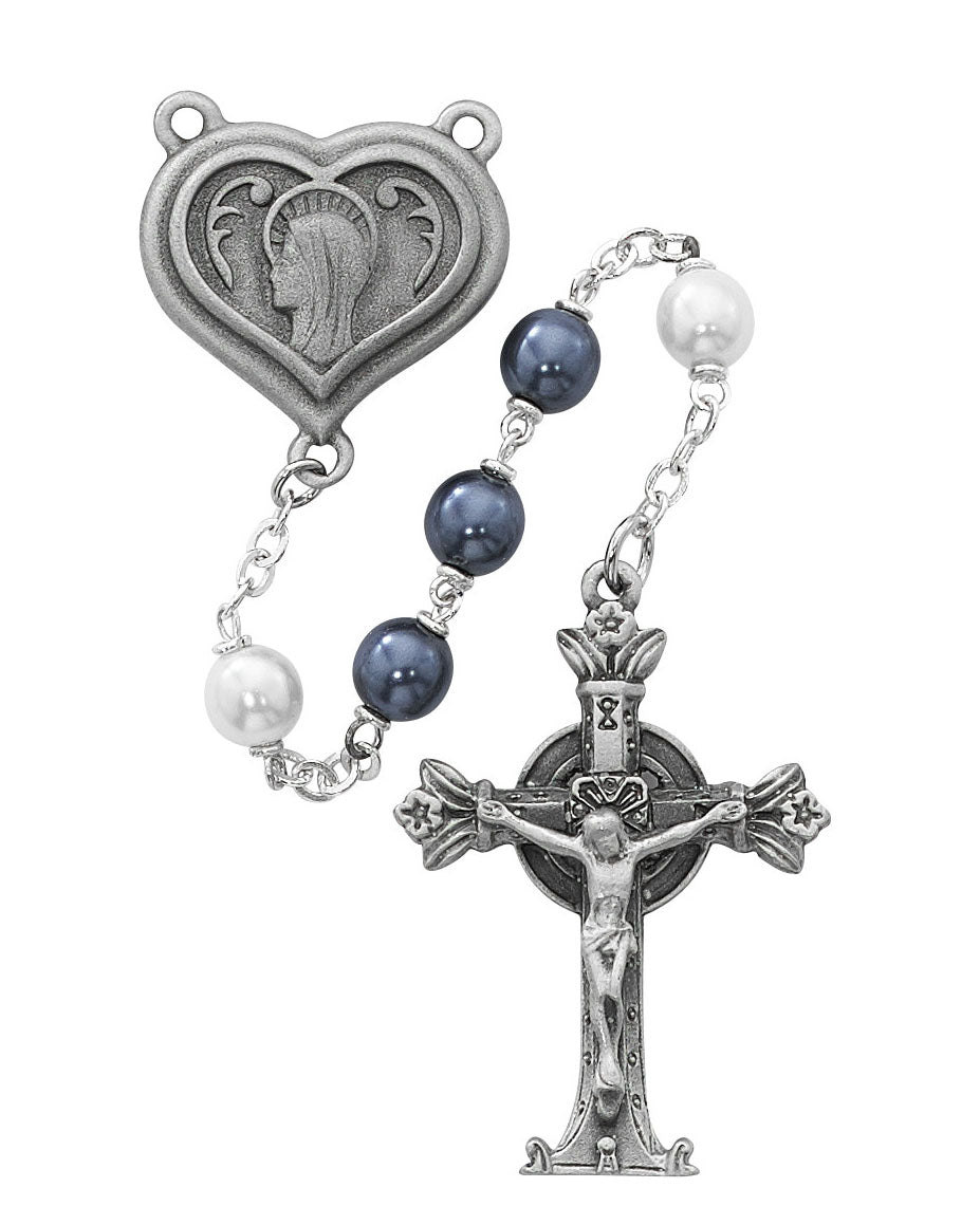Rosary with heart-shaped Our Lady of Lourdes medal, blue and white pearl beads, and crucifix on a white background.