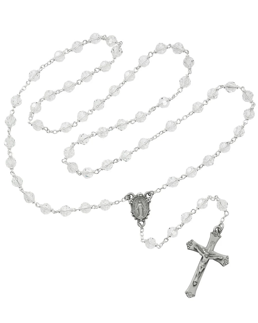 Rosary with white beads and silver cross on a white background