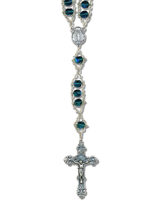 Silver rosary with blue gemstones on a white background