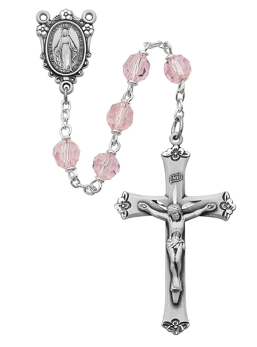 Silver rosary with pink beads on a white background
