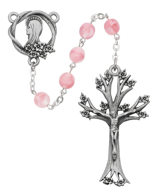 Rosary with pink beads and silver tree-shaped cross on a white background